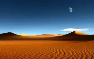 Sand dunes in desert with blue sky background